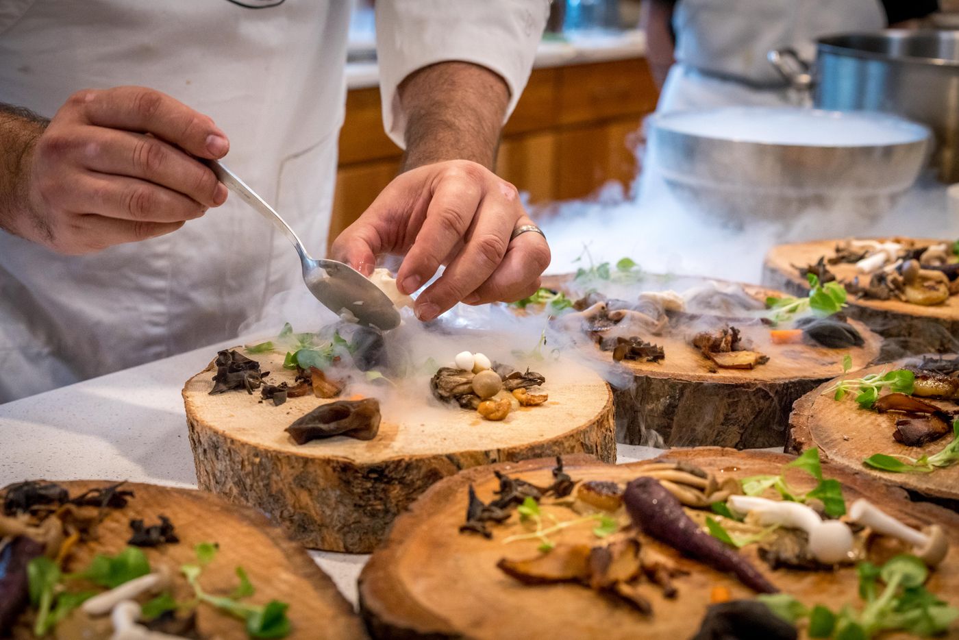 Chef carefully plating small dishes in a restaurant kitchen